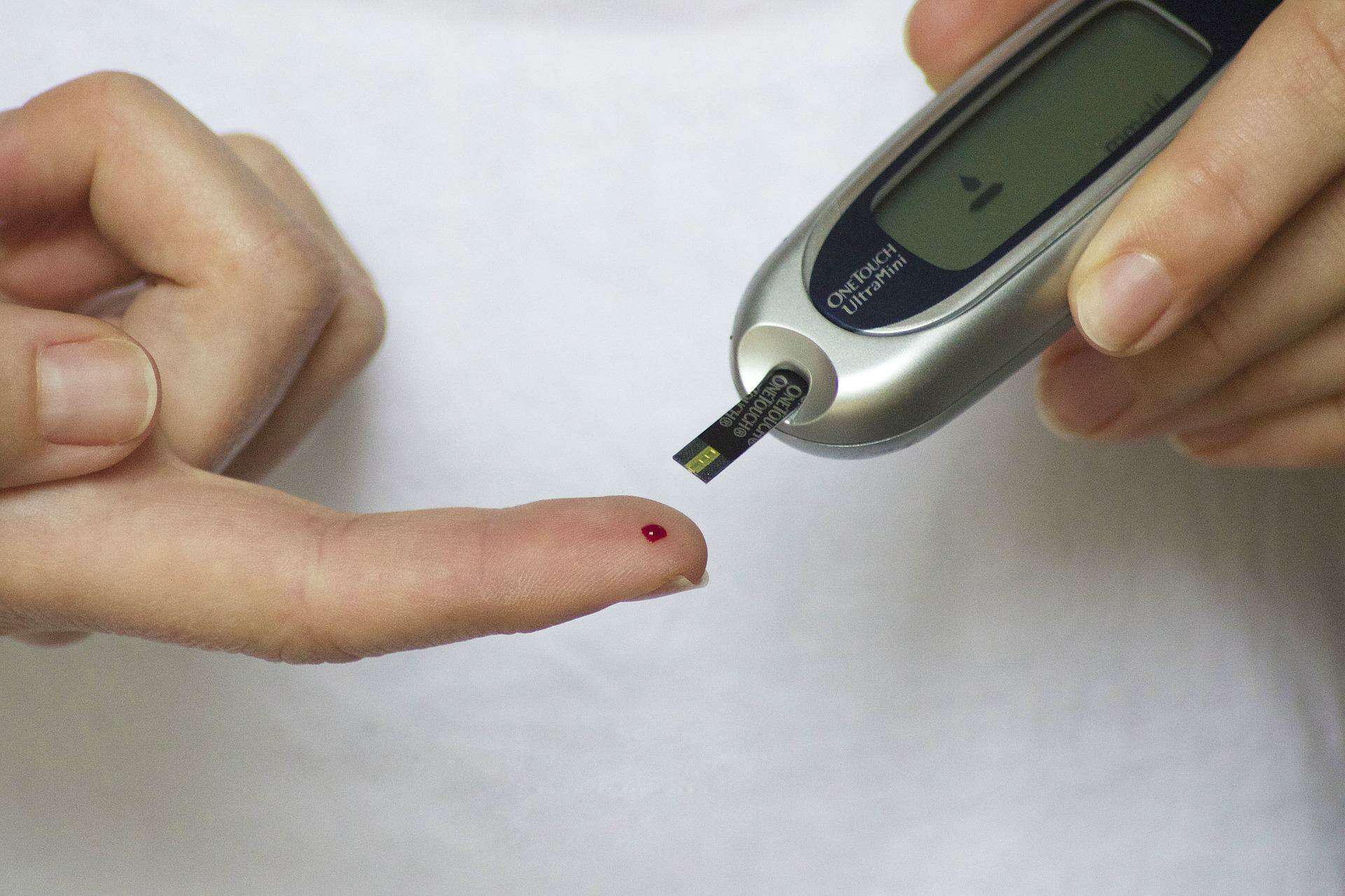 blood drop on finger and glucose monitor